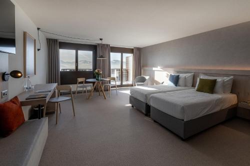 a hotel room with a bed and a table and chairs at Victoria Hotel & Residence in Villars-sur-Ollon