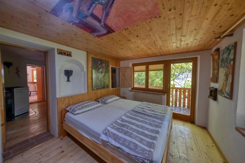 una camera con letto e soffitto in legno di Cottage surrounded by forests - The Sunny Hill 