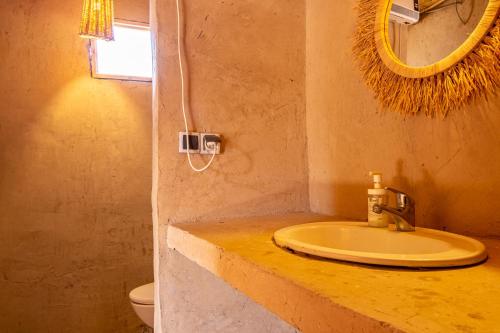 a bathroom with a sink and a mirror and a toilet at Agafay, La Ferme Nomade Bivouac in El Karia