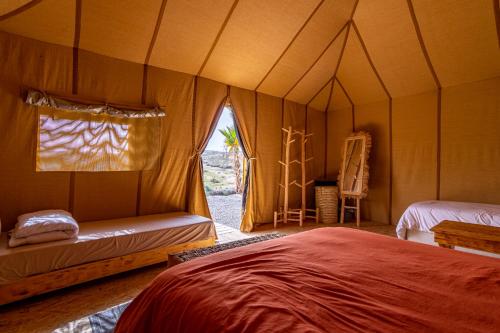 a bedroom with a bed in a tent at Agafay, La Ferme Nomade Bivouac in El Karia