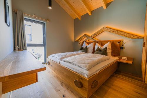 1 dormitorio con cama de madera en una habitación con ventana en Holzspan en Seiffen