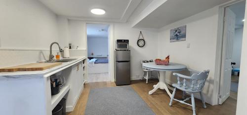 a kitchen with a sink and a table in it at Private 2-Bedroom Minutes From Trent University in Peterborough