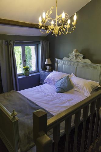 Schlafzimmer mit einem Bett mit Kronleuchter in der Unterkunft Petite Maison de Mouton in Azat-le-Riz