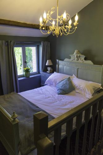 - une chambre avec un lit et un lustre dans l'établissement Petite Maison de Mouton, à Azat-le-Riz