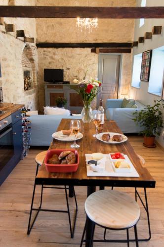 einen Tisch mit Teller mit Speisen und Gläsern Wein in der Unterkunft Petite Maison de Mouton in Azat-le-Riz