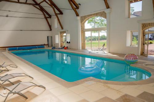 une piscine avec de l'eau bleue dans une maison dans l'établissement Le Loft de Souhey, à Souhey