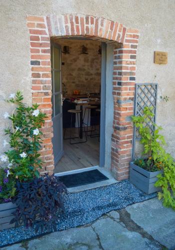 einen Eingang zu einem Backsteingebäude mit einem Tisch in der Unterkunft Petite Maison de Mouton in Azat-le-Riz