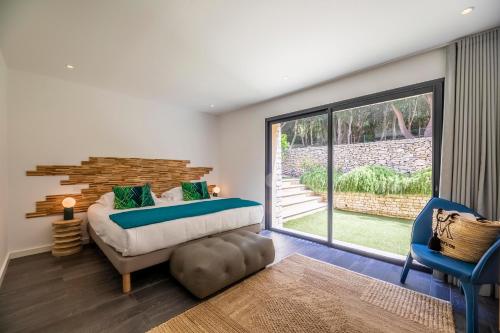 Villa du Couvent Version Maquis في بونيفاسيو: غرفة نوم بسرير ونافذة كبيرة