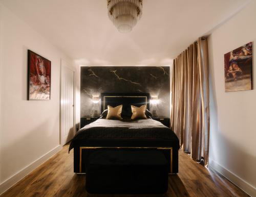 Schlafzimmer mit einem großen Bett mit einem schwarzen Kopfteil in der Unterkunft Casa Amor - Kinky Hotel UK in Southampton
