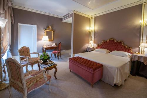 a bedroom with a bed and a table and chairs at Ca' Sagredo Hotel in Venice