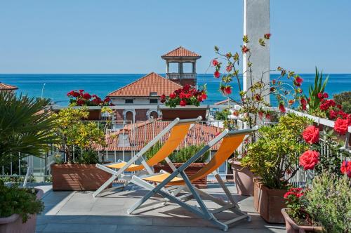 un par de sillas sentadas en un balcón con flores en Hotel Scandinavia, en Marina di Massa