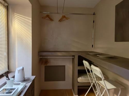 eine Küche mit 2 Stühlen, einer Theke und einem Tisch in der Unterkunft Alloggio Turistico MOLU in Gavazzo Nuova