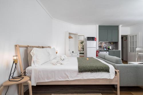 a bedroom with a white bed and a kitchen at BeGuest Cascais Cozy Studio in Cascais