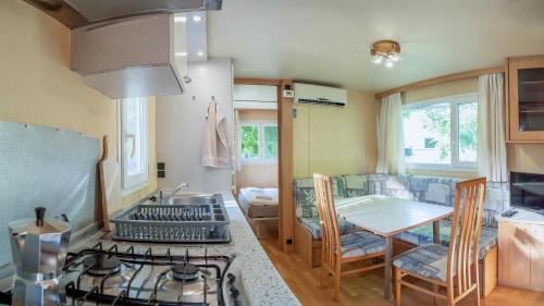 a kitchen with a stove top oven next to a table at Tíztó Vendégház in Baja