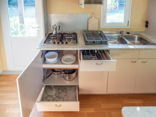 a kitchen with a stove and a sink at Tíztó Vendégház in Baja
