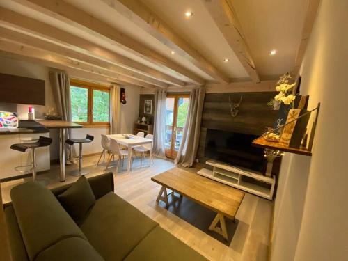 un soggiorno con divano verde e tavolo di Appartement La Suite du Kandahar à Chamonix a Chamonix-Mont-Blanc