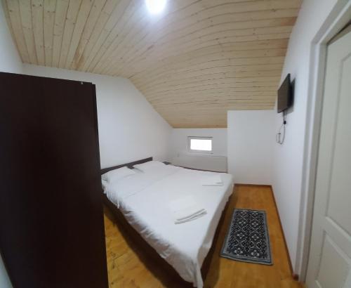 Cama en habitación pequeña con techo de madera en Casa Arabela, en Vişeu de Sus