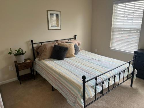 a bed with pillows on it in a bedroom at Stylish, Cozy Corporate Townhome with Pool! in Greensboro