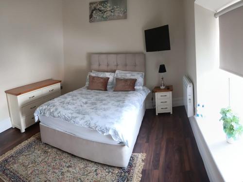 a bedroom with a white bed and a rug at THE LODGE (Belmullet town centre) in Belmullet