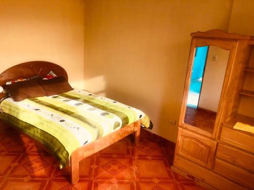 um pequeno quarto com uma cama e um espelho em Posada de Nirvana em Urubamba