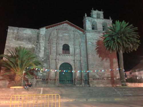 eine große Steinkirche mit Palmen davor in der Unterkunft Posada de Nirvana in Urubamba