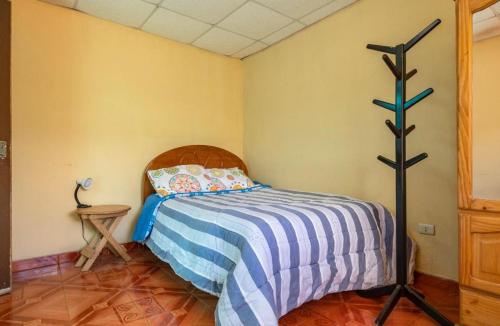 ein Schlafzimmer mit einem Bett mit einer blau-weißen gestreiften Decke in der Unterkunft Posada de Nirvana in Urubamba