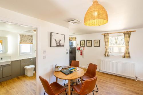 a kitchen and dining room with a table and chairs at Gorse Lodge 9 with Hot Tub in Belladrum