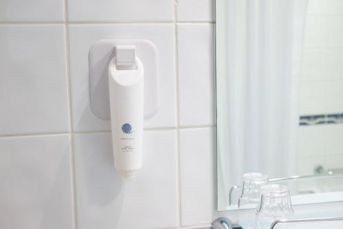 a bottle of hair conditioner on a wall next to a mirror at Antelope by Greene King Inns in Poole