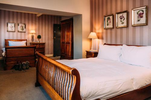 1 dormitorio con 1 cama grande con sábanas blancas en The Shireburn Arms, en Clitheroe