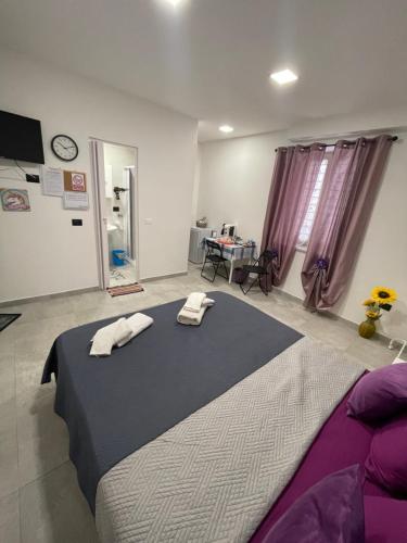 a bedroom with a large bed with two towels on it at Tufaro B&B Private Room in Macerata Campania
