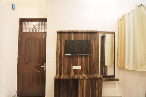 a room with a door and a television and a mirror at Hotel Keshavam inn in Mathura