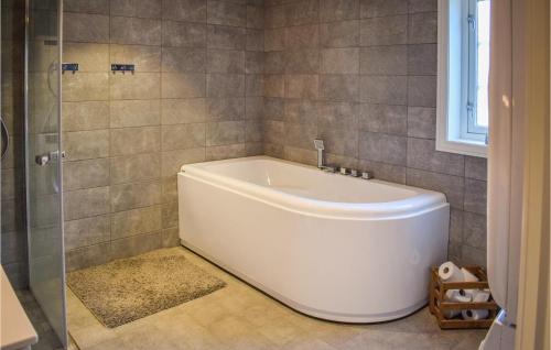 a white bath tub in a bathroom with a shower at Lovely Home In Passebekk With Wifi in Omholt