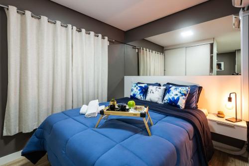 a bedroom with a blue bed with a table on it at Rover 1011 Centro in Sao Paulo