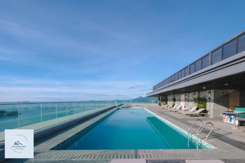 a swimming pool in a building next to the water at Bluewaves Apartment Quy Nhon in Quy Nhon