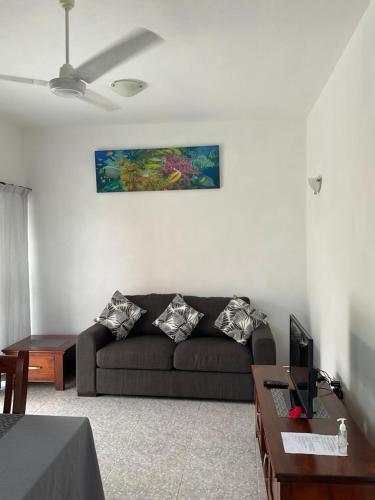 a living room with a couch and a table at Didi's Dream apartments in Anse Kerlan