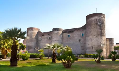 a large castle with palm trees in front of it at La Casa di Nino in Catania