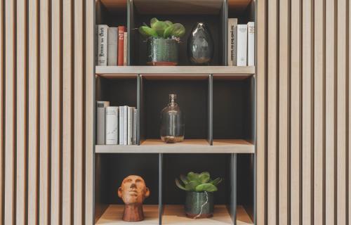 a book shelf with books and plants on it at Langwies Genussherberge in Hallein