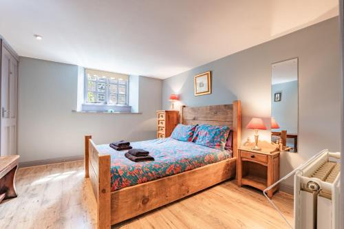 a bedroom with a wooden bed and a mirror at Nine Ladies in Matlock
