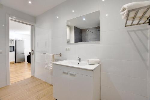 uma casa de banho branca com um lavatório e um espelho em Perfect apartment for beach lovers, next to the sailing club em El Arenal