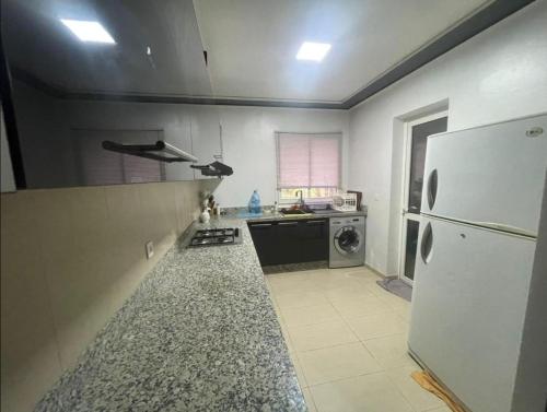 eine Küche mit einem weißen Kühlschrank und einem Herd in der Unterkunft Luxus Home in Oujda
