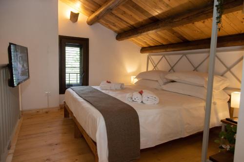 een slaapkamer met een bed met handdoeken erop bij Villa Tatai Country House by Dimore Trinacria in Belvedere