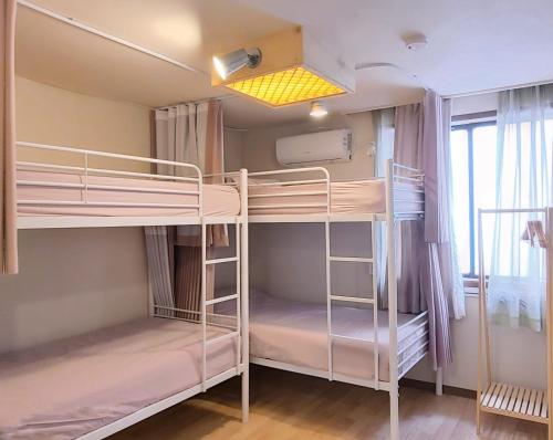 a room with two bunk beds and a window at Batwo Stay - For foreigners only in Seoul