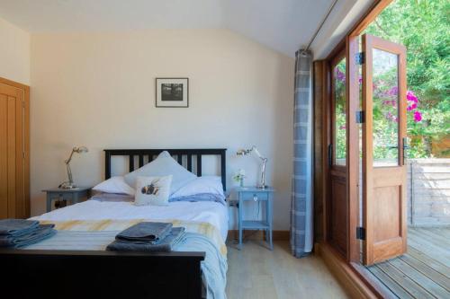 a bedroom with a bed and a sliding glass door at The Tack Room - rural boutique retreat for two in Clapham