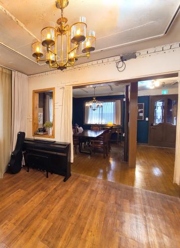 a living room with a piano and a dining room at Batwo Stay - For foreigners only in Seoul