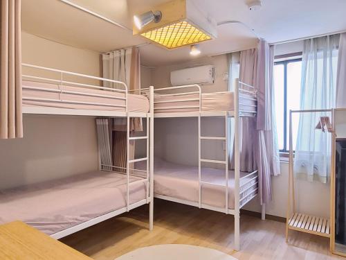 a room with two bunk beds and a window at Batwo Stay - For foreigners only in Seoul