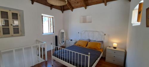 ein kleines Schlafzimmer mit einem Bett mit blauer Bettwäsche und gelben Kissen in der Unterkunft The Retreat in the heart of Old Town Rhodes in Rhodos (Stadt)