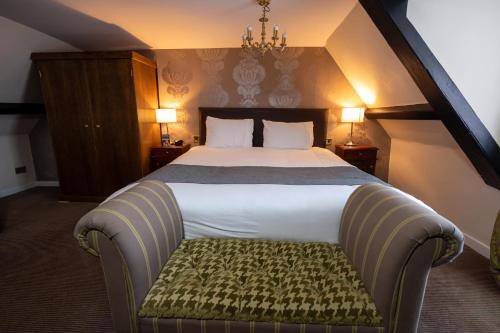 a bedroom with a large bed with a bench in it at Antelope by Greene King Inns in Poole