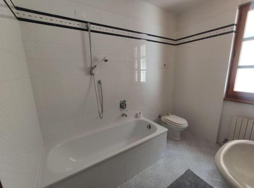 baño blanco con bañera y aseo en La Capanna, en Marradi