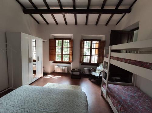 a bedroom with a bunk bed and two windows at La Capanna in Marradi