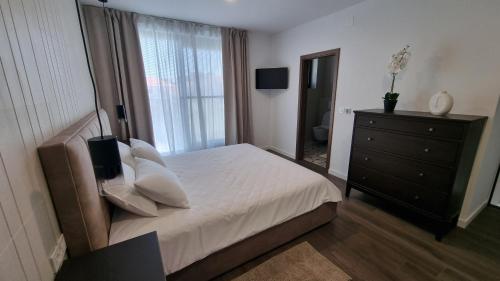 1 dormitorio con 1 cama, vestidor y ventana en Delta House - Beta apartment, en Zadar